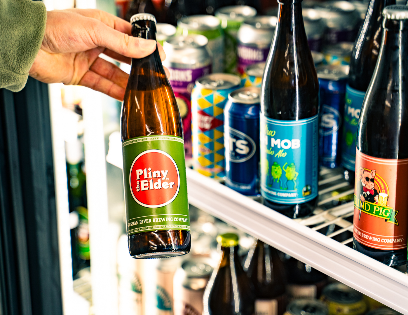 Hand grabbing Pliny the Elder from our craft beer cooler