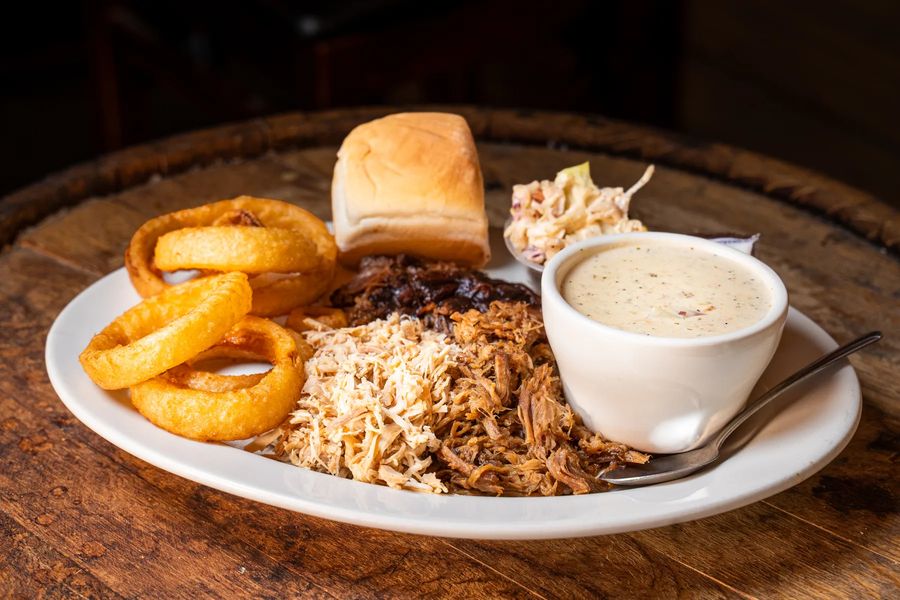 Combo Platter of slow-smoked pulled pork and pulled chicken with onion rings at Hop N Grape in Longview, WA